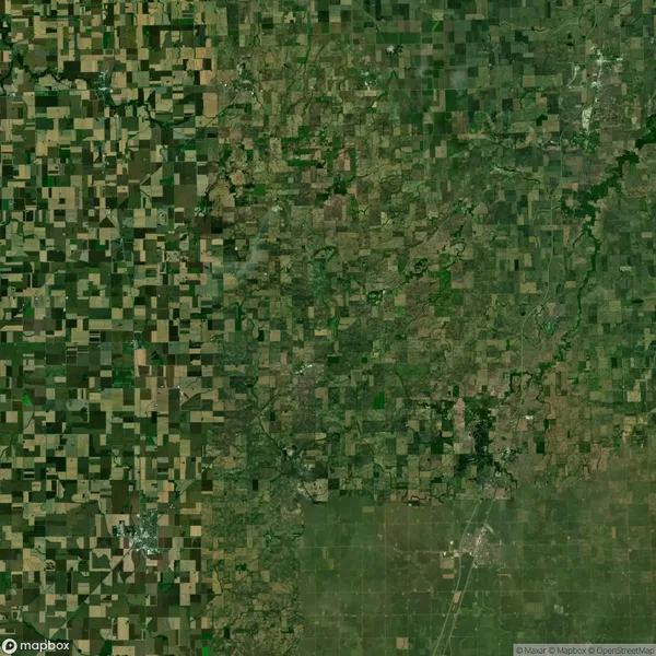 Aerial view of a rural landscape showing a patchwork of agricultural fields and green areas, indicating farmland and undeveloped land.