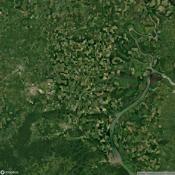 Aerial view of a landscape with a river winding through a patchwork of green and brown agricultural fields and forests.