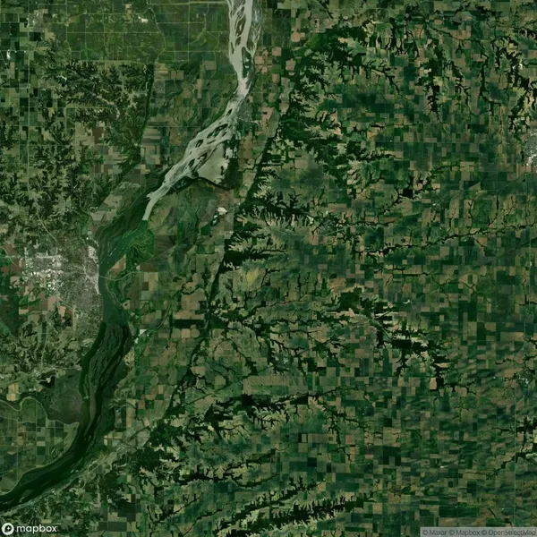 Aerial view of a landscape featuring a lush green expanse with a prominent river cutting through the terrain, surrounded by patchwork fields and varying vegetation.