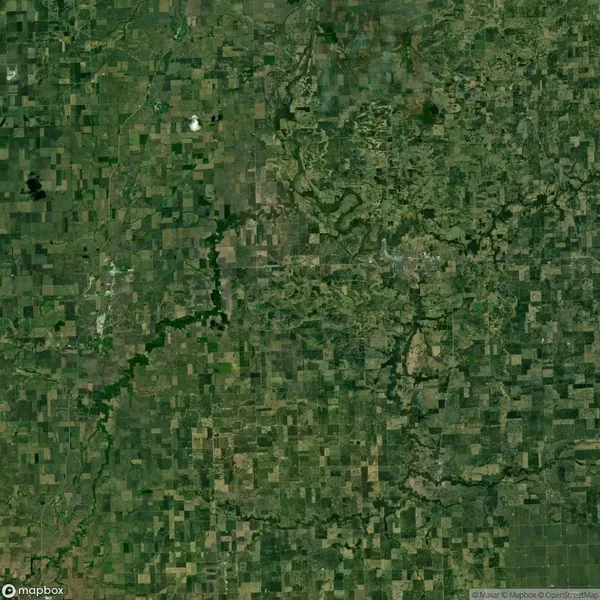 Aerial view of a vast patchwork of green and brown agricultural fields with rivers winding through the landscape.