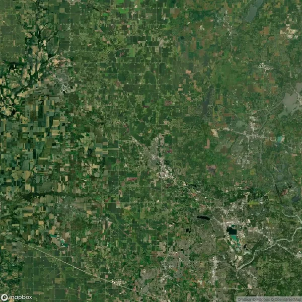 Satellite view of a mostly green, agricultural landscape with scattered patches of urban development, roads, and waterways.