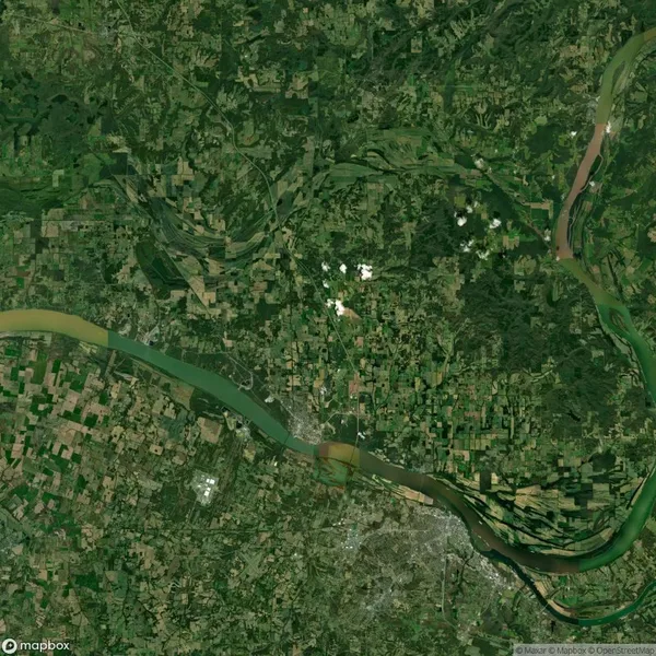 Aerial view of a landscape with a large river meandering through green and brown agricultural fields, surrounded by patches of forested areas.