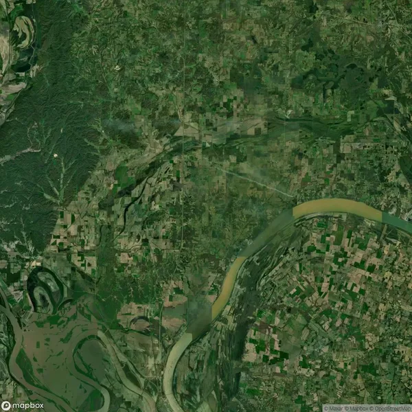 Aerial view of a river winding through a green, forested area and surrounding farmlands and fields, with a visible patchwork of agriculture and natural landscape.