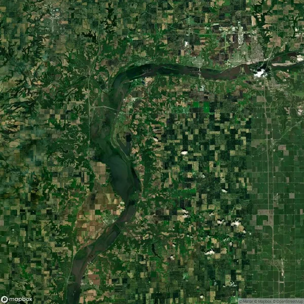 Aerial view of a river winding through a patchwork of agricultural fields and forested areas, showing a diverse landscape pattern.