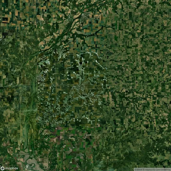 Aerial view of a rural landscape showing a mix of agricultural fields, forested areas, and a network of roads and rivers.