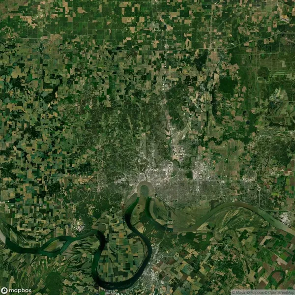 Satellite view of a vast, patchwork landscape with agricultural fields, a river winding through the bottom, and a densely populated area at the center.