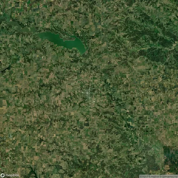 Satellite view of a rural landscape with fields, forests, and a lake located in the upper left quadrant.