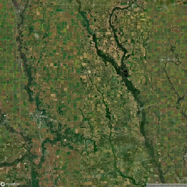 Satellite image of a large, varied landscape with agricultural fields in a grid pattern and winding rivers. Patches of dense greenery are interspersed throughout.