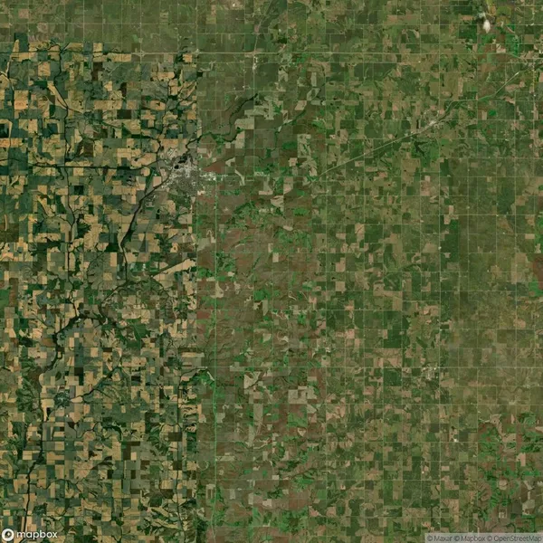 Satellite view showing a landscape divided by a river, with farmland on both sides and a small town in the upper left quadrant.