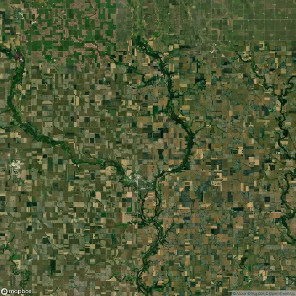 Aerial view of a patchwork of agricultural fields with a winding river running through the landscape.