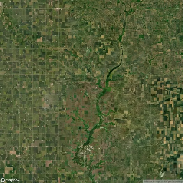 Aerial view of a landscape with a river running through it, surrounded by patchwork agricultural fields and varied green vegetation.