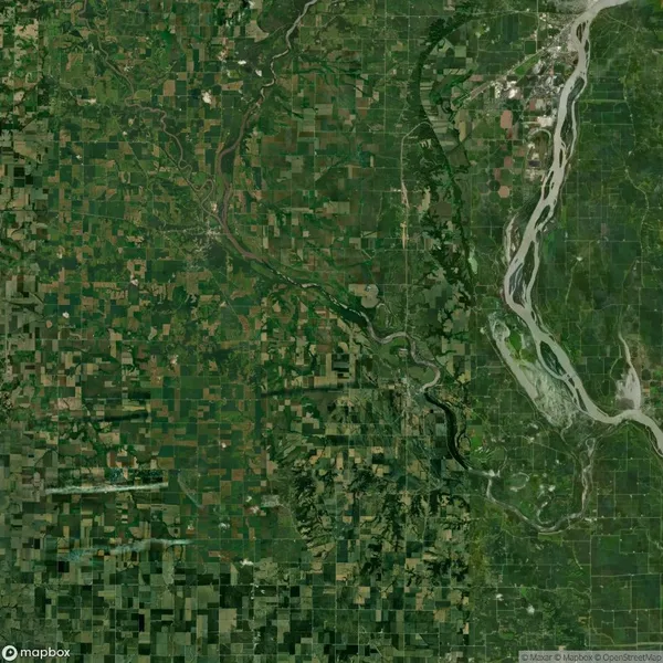 Satellite view of a landscape showing a patchwork of agricultural fields on the left and a winding river on the right.
