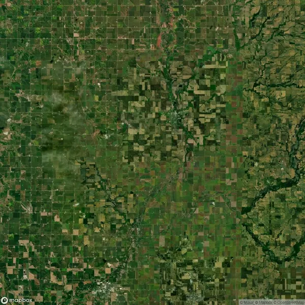 Aerial view of a patchwork of agricultural fields and natural areas, featuring a grid pattern of varying shades of green and brown, intersected by water bodies.