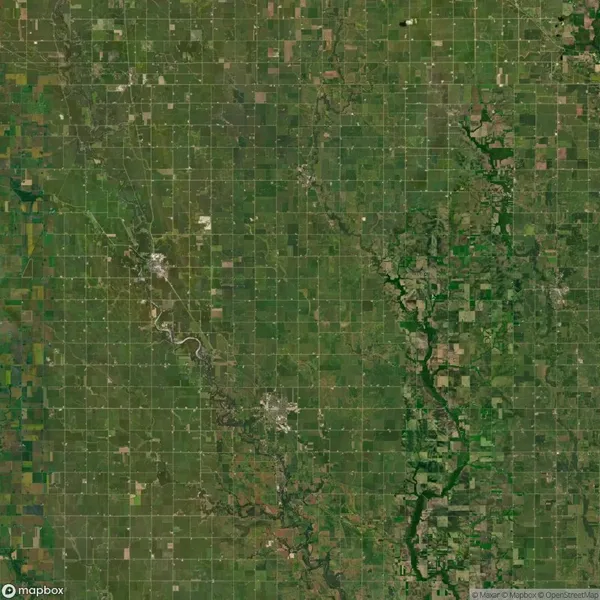 Aerial view of a large, grid-like agricultural landscape with patches of green fields and a winding river cutting through the area.