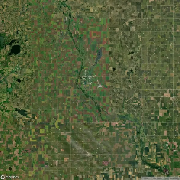 Aerial view of a large, rectangular patchwork of agricultural fields with a river running through the center, surrounded by a dense network of country roads.