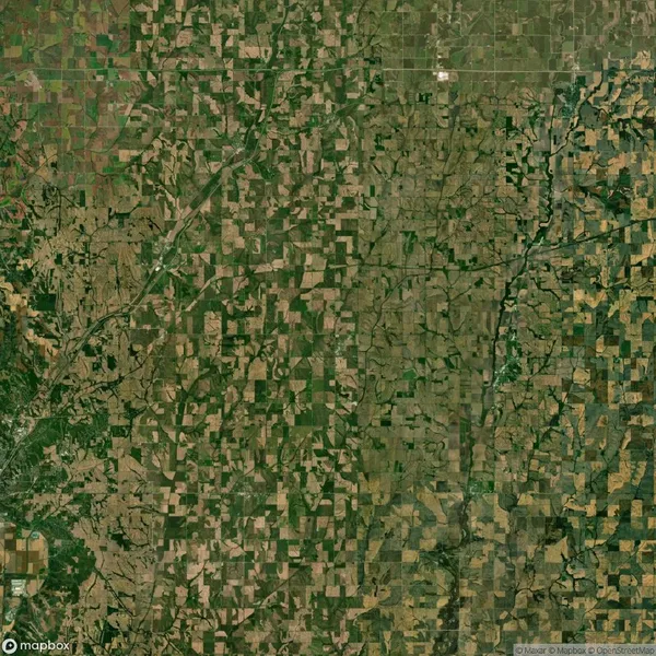 Aerial view of a rural landscape with a patchwork of agricultural fields and a river meandering through the countryside.