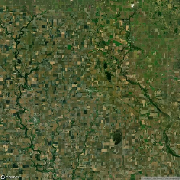 Aerial view of a landscape showing a patchwork of agricultural fields and winding rivers, with varied shades of green and brown.