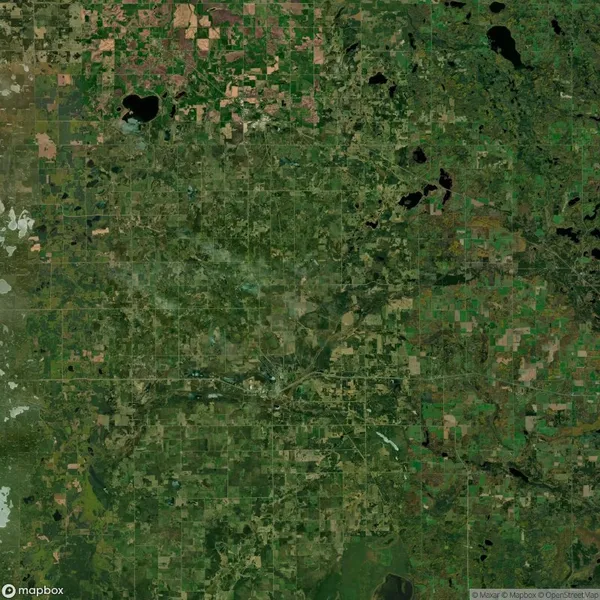 Satellite view of a lush, patchwork landscape with green fields, forests, and small bodies of water in North Dakota, USA. Roads intersect the area at various points.