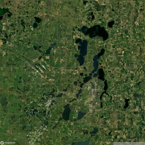 Satellite view of a landscape showing numerous lakes, roads, and patches of greenery.