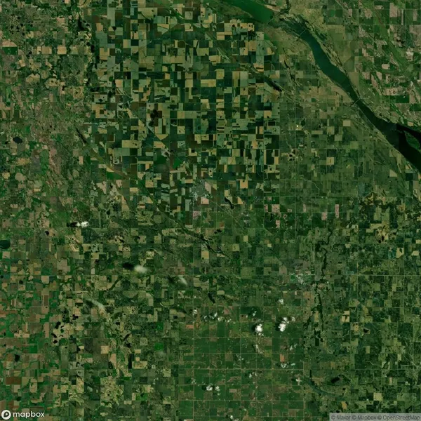 Aerial view of a vast, patchwork landscape of agricultural fields, forests, and a winding river at the top.