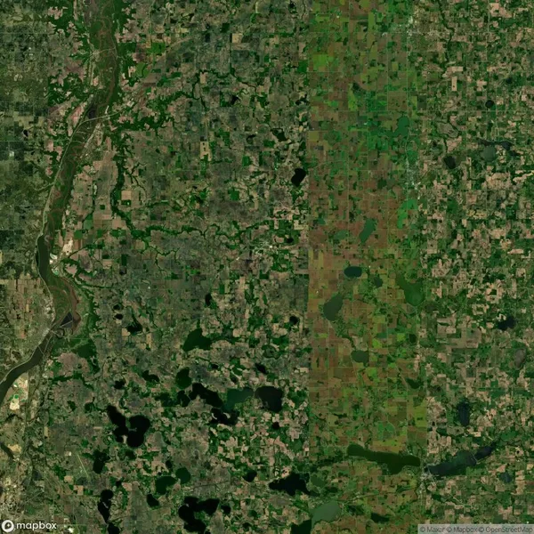 Satellite image displaying a patchwork of farmland, forests, and water bodies. A river flows through the left side, with a variety of green and brown hues across the landscape.