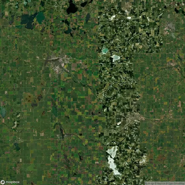 Satellite image showing a large, green agricultural landscape with scattered bodies of water and patches of urban development.
