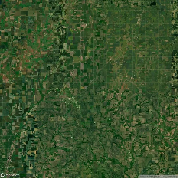 Aerial view of a rural landscape with a patchwork of fields, roads, and areas of dense vegetation.