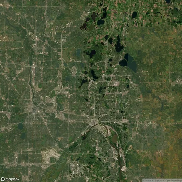 Satellite view of a green and urban landscape with rivers and lakes visible, featuring a network of roads and varying patches of development.