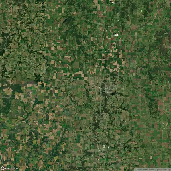 Aerial view of a patchwork landscape featuring agricultural fields and patches of green vegetation.