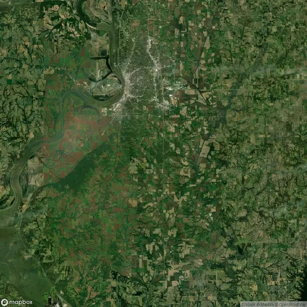 Aerial view of a sprawling landscape with a river, green fields, and a dense urban area near the river's bend.