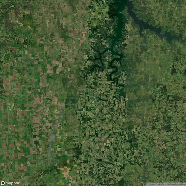 Aerial view of a landscape with patchwork fields and a winding river running vertically through the center.