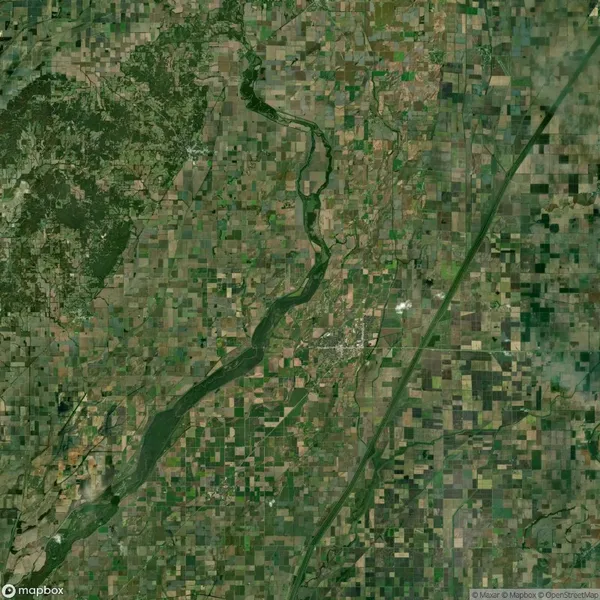 Aerial view of a river flowing through a patchwork of agricultural fields and a grid layout of land plots.