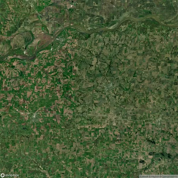 Aerial view of a rural landscape with patchwork farmland and winding rivers, displaying a mix of green and brown fields.