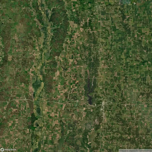 Aerial view of a patchwork landscape featuring fields, rivers, and patches of forest. The area includes a mix of agricultural land and natural greenery.