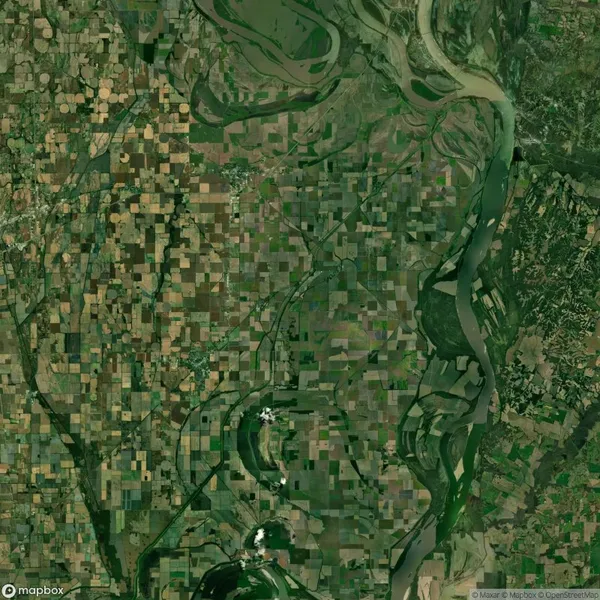 Aerial view of patchwork farmland intersected by winding rivers and scattered with small towns, surrounded by dense greenery.