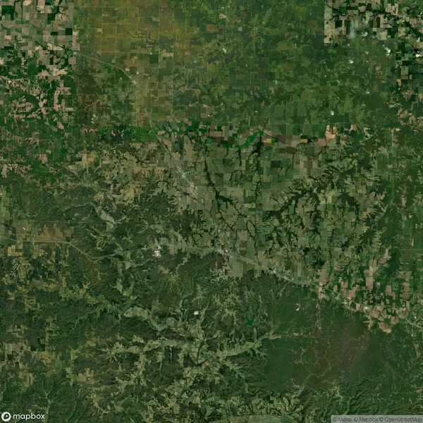 Aerial view of a landscape showing a mix of farmland and wooded areas, with visible rivers and roads intersecting the terrain.