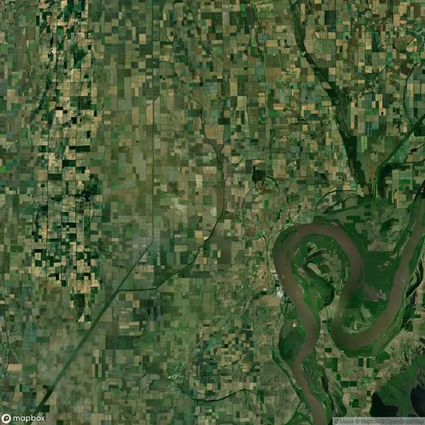 Satellite view of a landscape with a patchwork of fields and a winding river in the lower right corner.