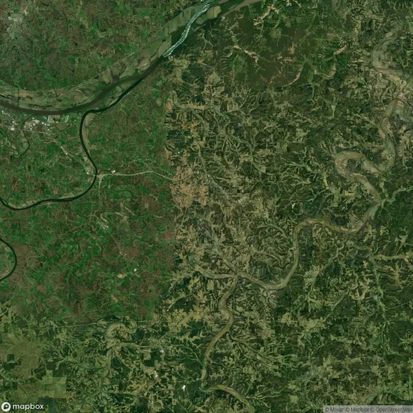 Aerial view showing a river winding through dense green forest and farmland, with a distinct division between two landscape patterns.