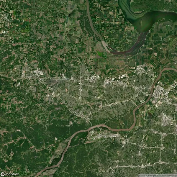 Aerial view of a green landscape with rivers and urban areas. A large river flows at the top right, surrounded by fields, and smaller waterways intertwine through the city below.