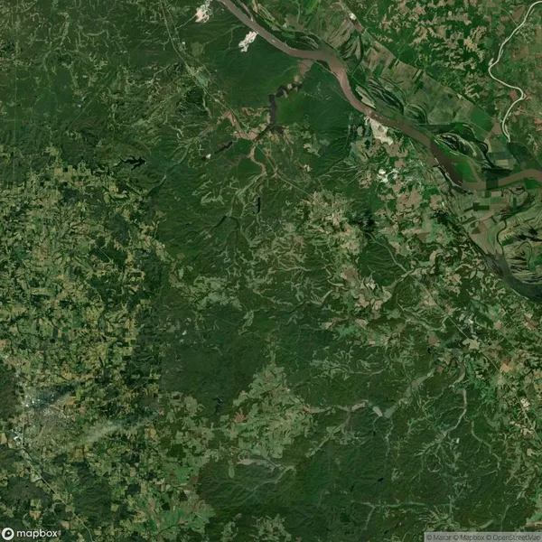 Aerial image of a vast green landscape with rivers, forests, and fields, intersected by winding paths and roads.