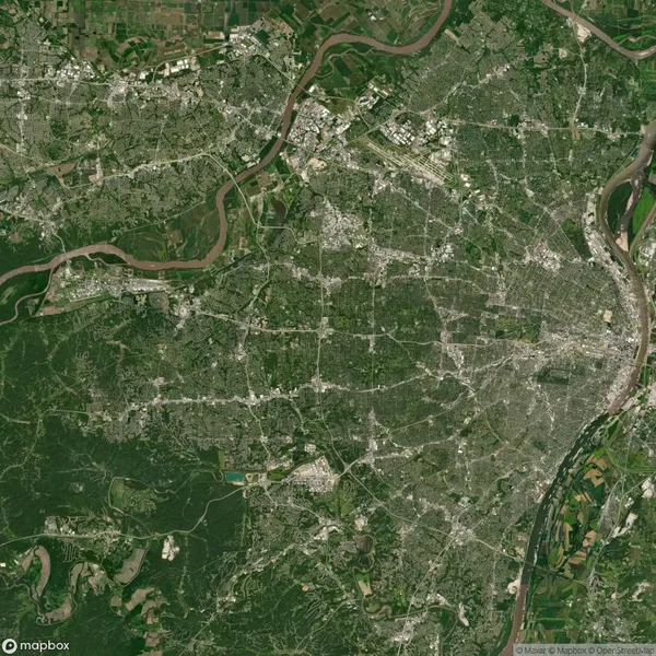 Satellite view of a city with a river running through it, surrounded by green areas and farmland, showing a network of roads and urban development.