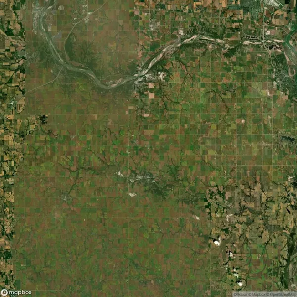 Aerial view of patchwork farmland with a river winding through the top section. Various shades of green and brown fields cover the landscape.