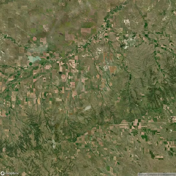 Aerial view of a vast patchwork of agricultural fields, rivers, and varying terrain in northwestern Nebraska, USA.