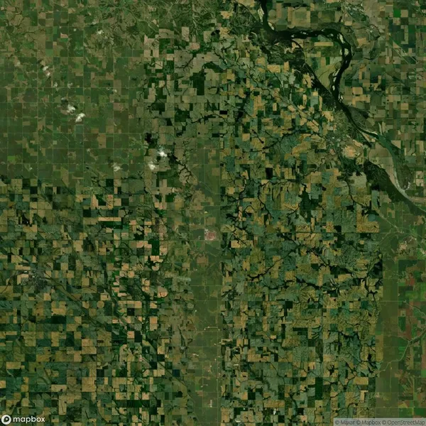 Aerial view of a patchwork landscape featuring agricultural fields and a winding river on the top right.