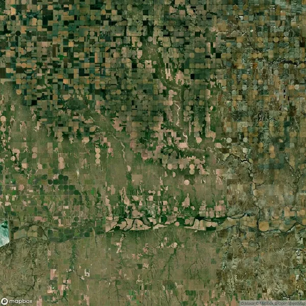Aerial view of agricultural lands with circular and grid-like field patterns, intersected by a winding river.