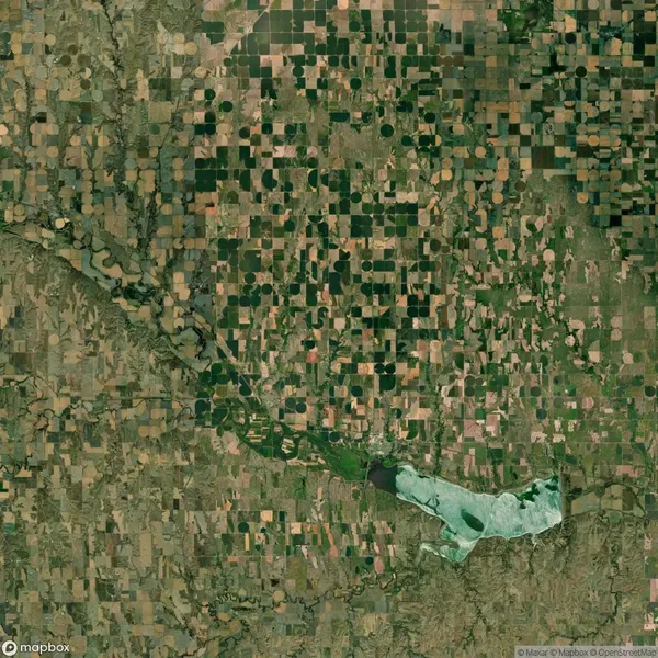 Aerial view of a patchwork landscape with square and circular agricultural fields surrounding a river and a body of water.