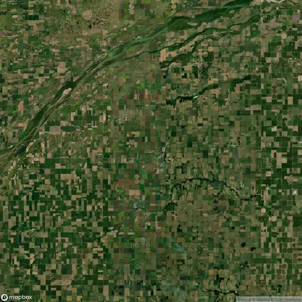 Aerial view of a large, flat agricultural landscape with patchwork fields and circular plots, intersected by a winding river.