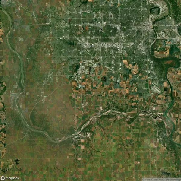 Satellite view of a landscape featuring a river flowing through a patchwork of agricultural fields and urban areas, with roads and varying vegetation visible.