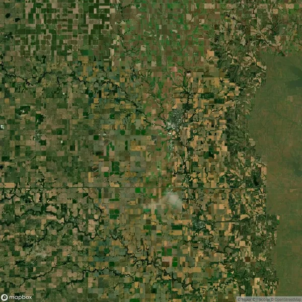 Aerial view of a landscape with a patchwork of agricultural fields, roads, and natural terrain.