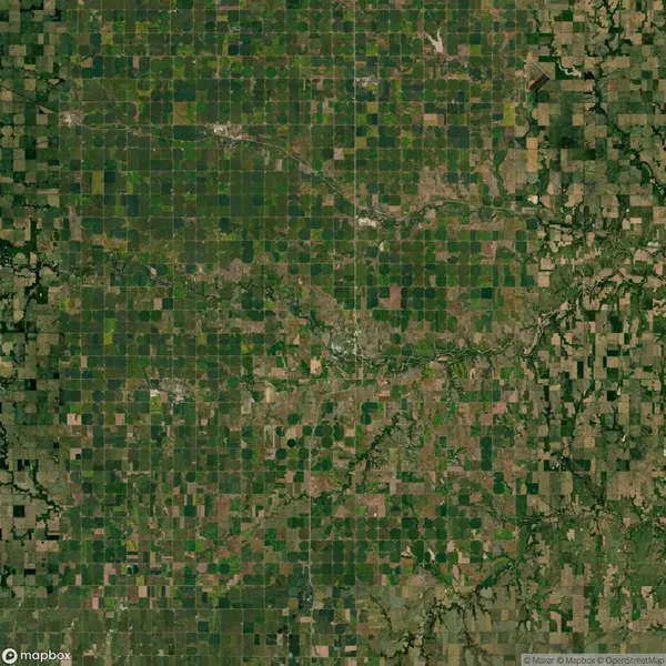 Aerial view of agricultural farmland with a grid pattern of fields and irregular patches, indicating mixed land use and natural formations.